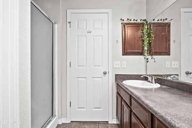 bathroom featuring a stall shower, vanity, and baseboards
