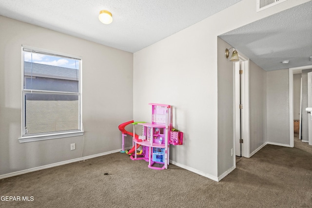 rec room with carpet flooring, baseboards, and a textured ceiling