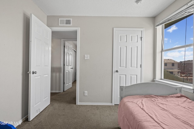 carpeted bedroom featuring baseboards and a textured ceiling