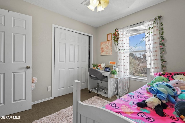 carpeted bedroom with a closet and baseboards