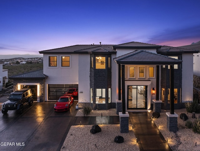 5905 Ojo De Agua Dr, El Paso, TX 79912 - view of front of property with stone siding, a garage, driveway, and stucco siding
