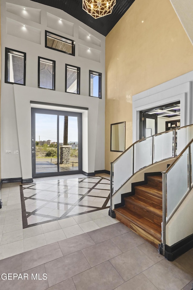 5905 Ojo De Agua Dr, El Paso, TX 79912 - foyer entrance with a high ceiling, baseboards, tile patterned flooring, stairway, and inlaid floor details