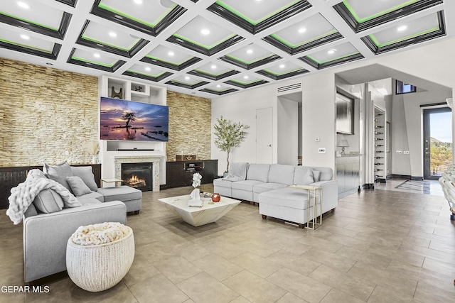 5905 Ojo De Agua Dr, El Paso, TX 79912 - living room featuring a warm lit fireplace, coffered ceiling, beamed ceiling, recessed lighting, and tile patterned flooring