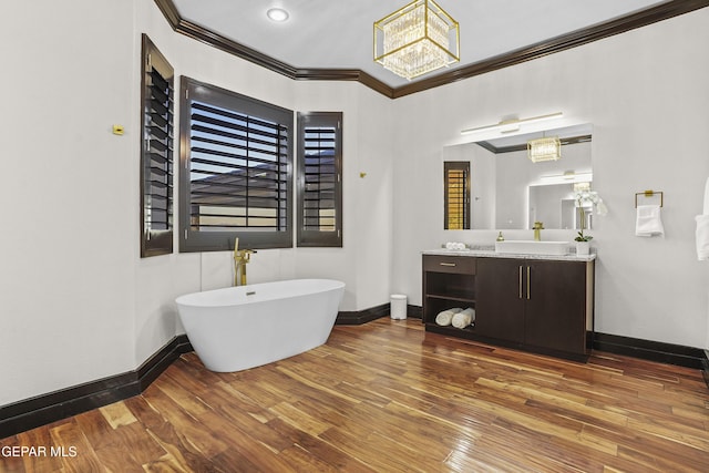 5905 Ojo De Agua Dr, El Paso, TX 79912 - full bath featuring crown molding, baseboards, hardwood / wood-style floors, a chandelier, and a soaking tub