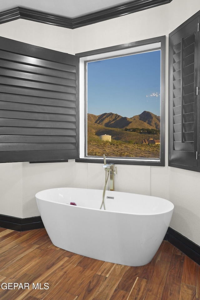 5905 Ojo De Agua Dr, El Paso, TX 79912 - full bath featuring wood finished floors, a freestanding tub, and baseboards