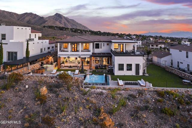 5905 Ojo De Agua Dr, El Paso, TX 79912 - back of house at dusk with a balcony, a mountain view, a patio area, outdoor lounge area, and stucco siding