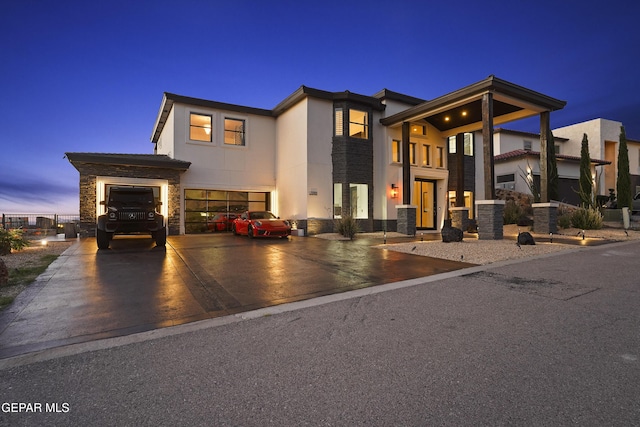 5905 Ojo De Agua Dr, El Paso, TX 79912 - contemporary home featuring stone siding, an attached garage, driveway, stucco siding, and central AC unit