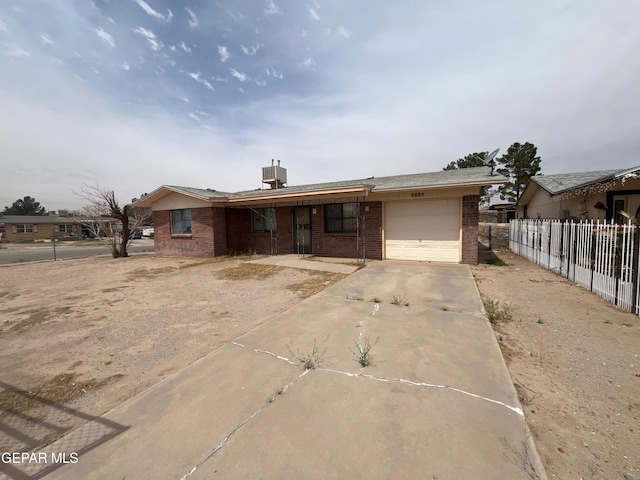 9885 Lilly Dr, El Paso, TX 79927 - single story home featuring an attached garage, fence, brick siding, and concrete driveway