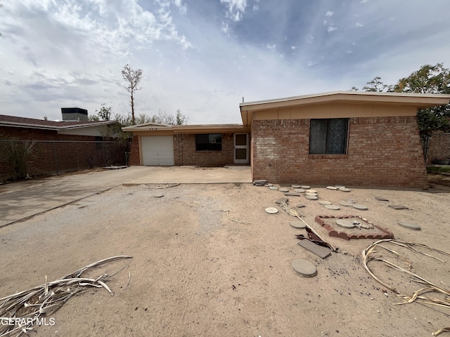 9874 Staubach Dr, El Paso, TX 79927 - rear view of house with brick siding, a garage, concrete driveway, and fence