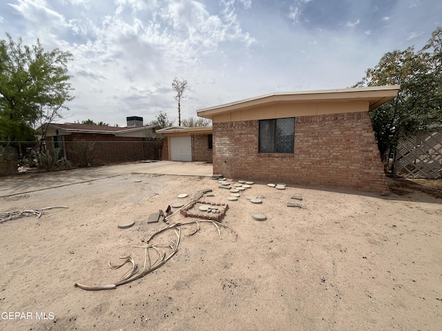 9874 Staubach Dr, El Paso, TX 79927 - back of property featuring brick siding, fence, driveway, and a garage