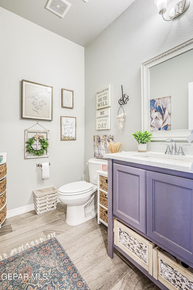 bathroom featuring wood finished floors, vanity, and toilet