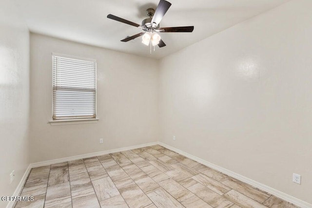 spare room featuring ceiling fan and baseboards
