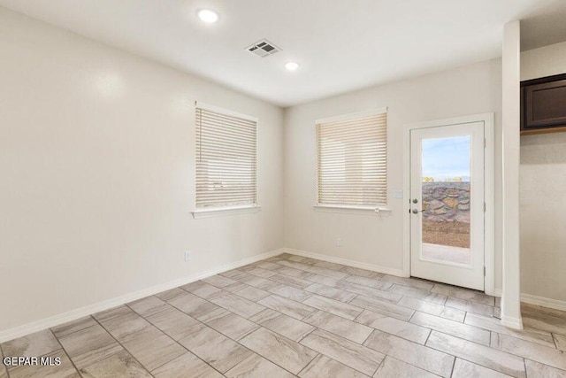 unfurnished room with recessed lighting and baseboards