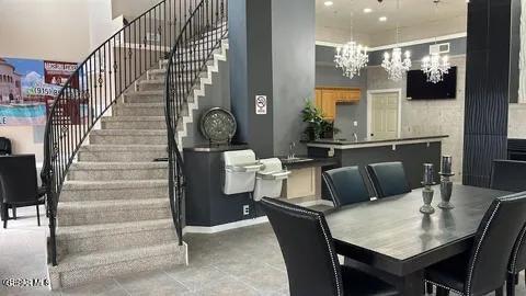12281 Costa Brava Dr, El Paso, TX 79936 - dining area with stairway, a high ceiling, and a chandelier
