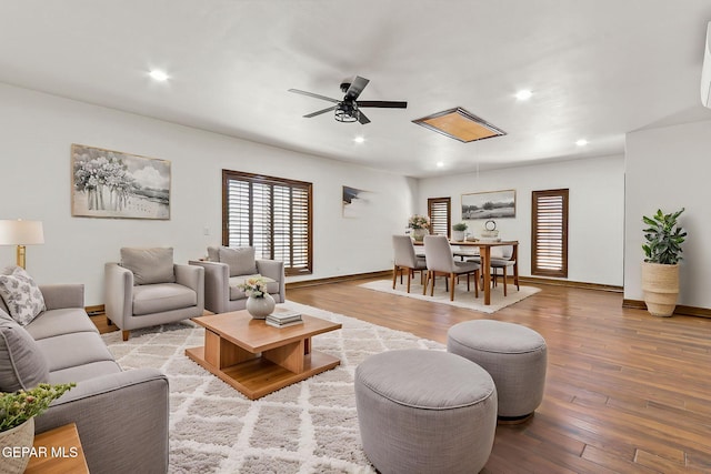 living area featuring a ceiling fan, hardwood / wood-style flooring, baseboards, and recessed lighting