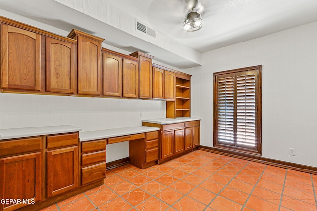 unfurnished office with built in study area and baseboards