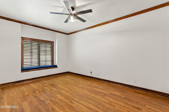 unfurnished room featuring ceiling fan, crown molding, wood finished floors, baseboards, and a textured ceiling