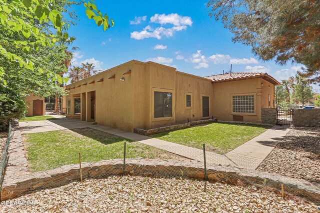 view of front of home featuring a gate, stucco siding, and a tile roof