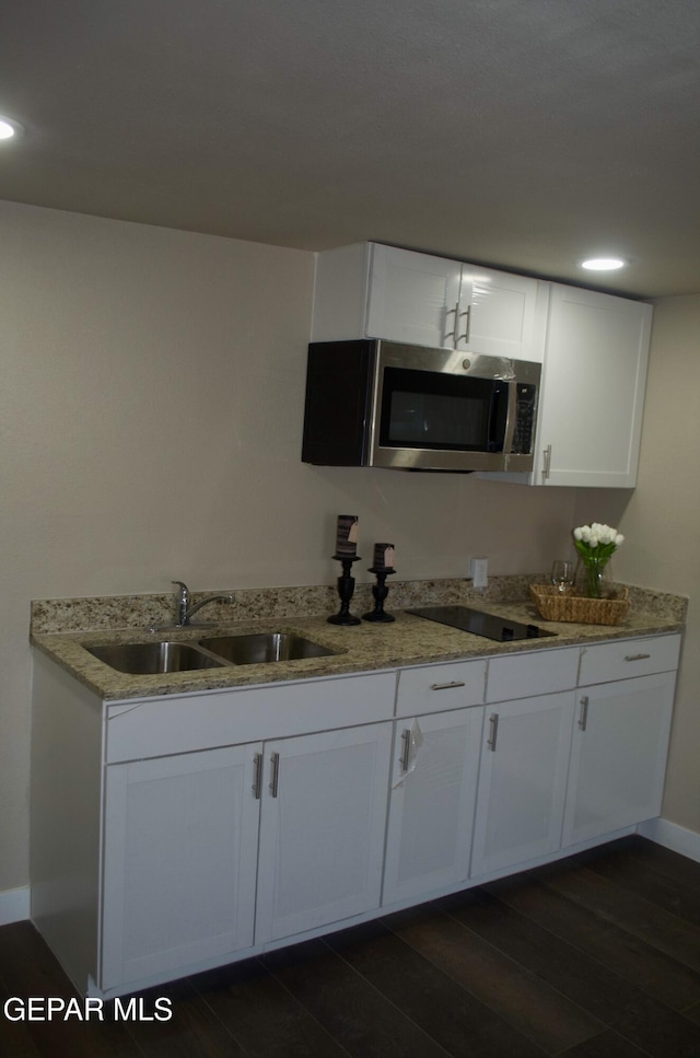3825 Trowbridge Dr, El Paso, TX 79903 - kitchen with stainless steel microwave, a sink, dark wood-style flooring, light stone countertops, and recessed lighting