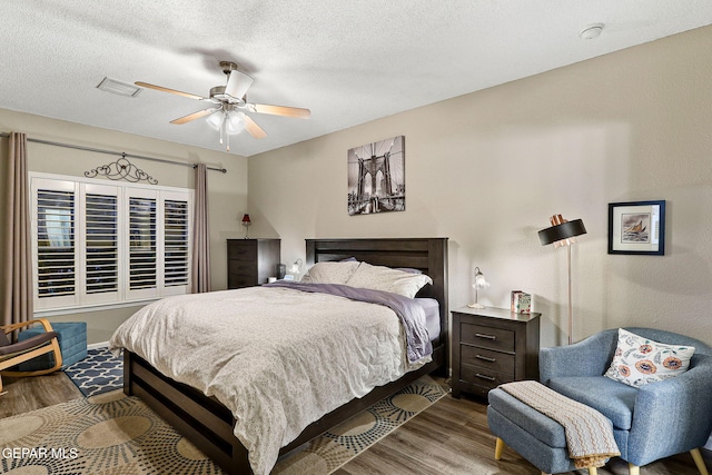 bedroom featuring wood finished floors, ceiling fan, and a textured ceiling