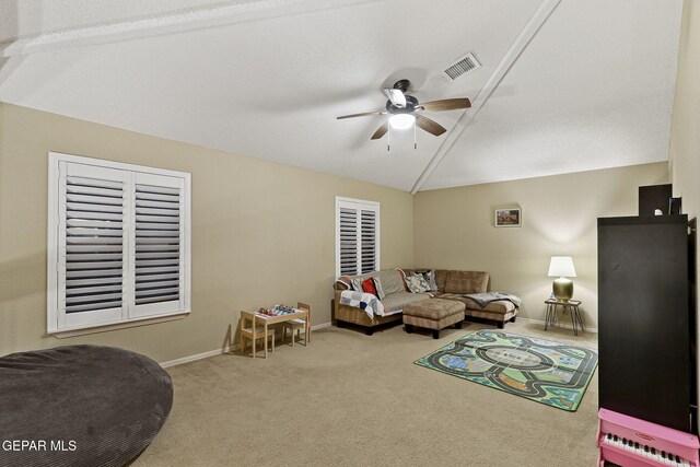 carpeted living room featuring a ceiling fan, vaulted ceiling, and baseboards