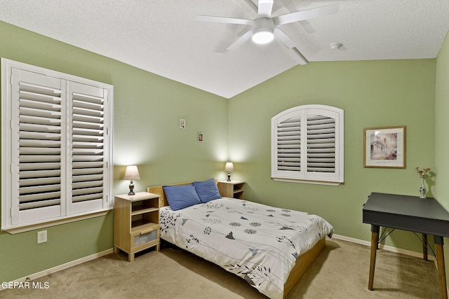bedroom featuring carpet, vaulted ceiling, baseboards, a textured ceiling, and ceiling fan