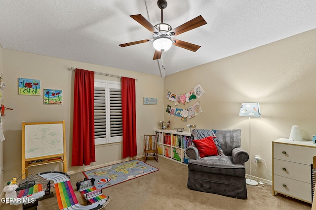 recreation room featuring a ceiling fan, carpet floors, baseboards, and a textured ceiling