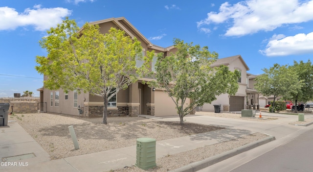 13824 Hollywood Dr, Horizon City, TX 79928 - view of property hidden behind natural elements with stucco siding, concrete driveway, an attached garage, and stone siding