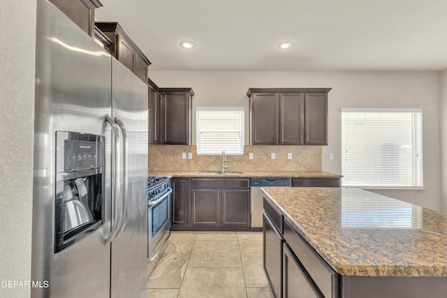 13824 Hollywood Dr, Horizon City, TX 79928 - kitchen with appliances with stainless steel finishes, a sink, dark brown cabinetry, backsplash, and recessed lighting