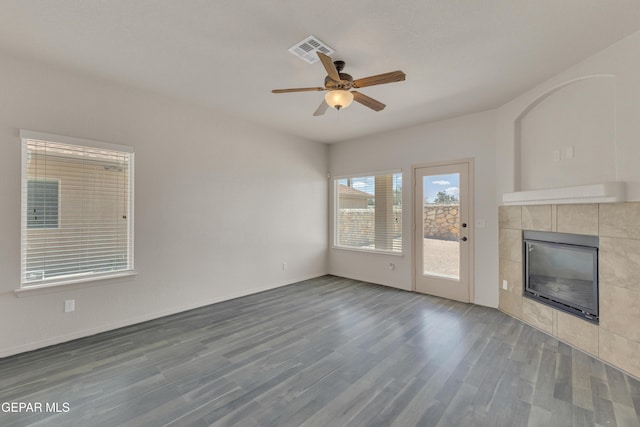 13824 Hollywood Dr, Horizon City, TX 79928 - unfurnished living room featuring a tiled fireplace, wood finished floors, a ceiling fan, and baseboards