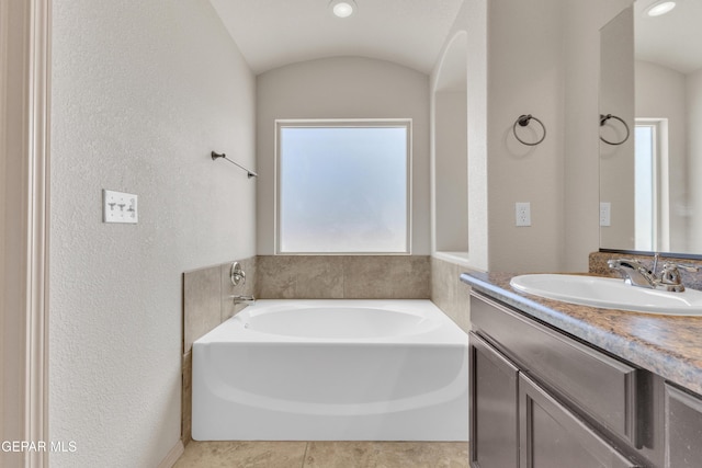 13824 Hollywood Dr, Horizon City, TX 79928 - full bathroom with a textured wall, vanity, a garden tub, and lofted ceiling