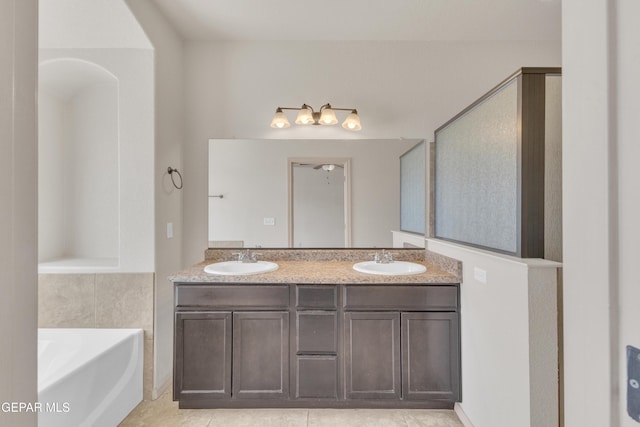 13824 Hollywood Dr, Horizon City, TX 79928 - bathroom featuring a garden tub, double vanity, and tile patterned flooring