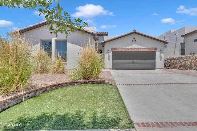 view of front of home with an attached garage, stucco siding, driveway, and a tile roof