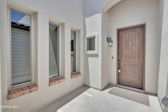 view of exterior entry featuring stucco siding