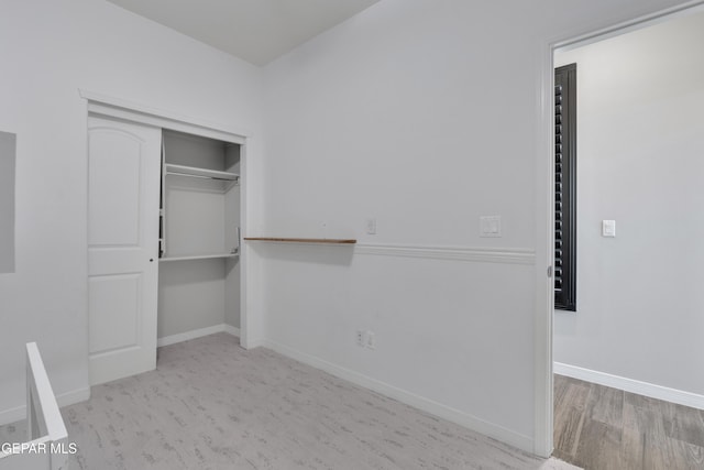 unfurnished bedroom with baseboards, a closet, and wood finished floors
