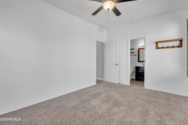 unfurnished bedroom with light colored carpet, baseboards, connected bathroom, and a ceiling fan