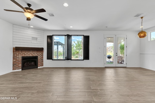 unfurnished living room featuring plenty of natural light, wood finished floors, a ceiling fan, and recessed lighting