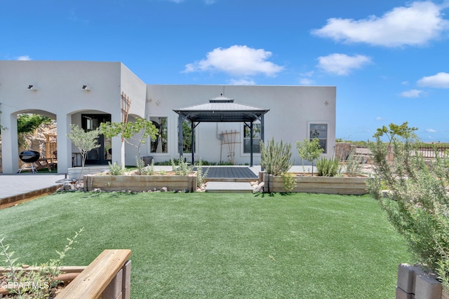 rear view of property with a gazebo and stucco siding