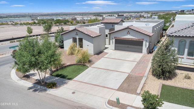 view of front facade with stucco siding, a garage, concrete driveway, and a tile roof