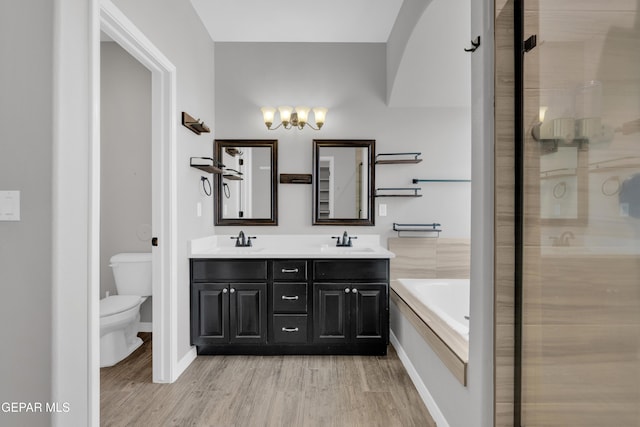 full bath featuring toilet, a shower stall, wood finished floors, and a chandelier