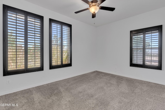unfurnished room featuring carpet, a ceiling fan, and baseboards