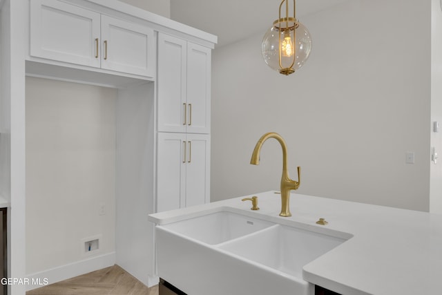 429 Lesa Ln, El Paso, TX 79915 - kitchen featuring a sink, decorative light fixtures, light countertops, white cabinets, and baseboards