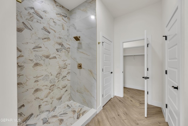 429 Lesa Ln, El Paso, TX 79915 - bathroom featuring a tile shower, wood finished floors, and a walk in closet