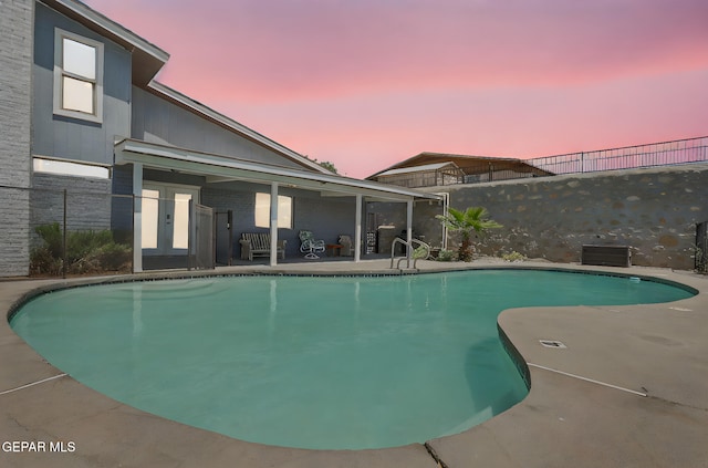 outdoor pool featuring a patio and fence