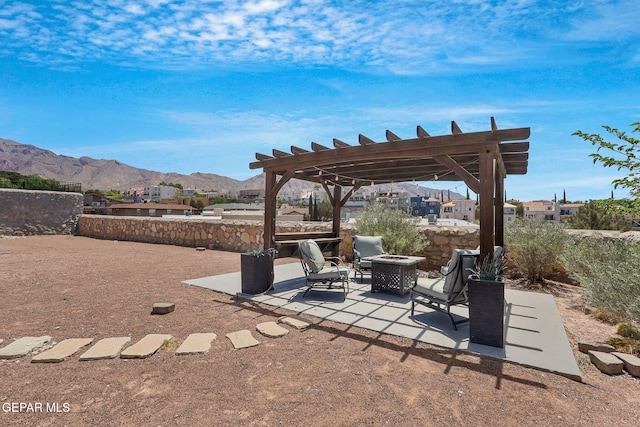 view of patio with a fire pit, a mountain view, and a pergola