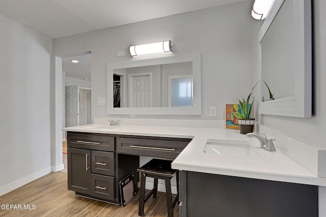 bathroom with wood finished floors, vanity, baseboards, and recessed lighting