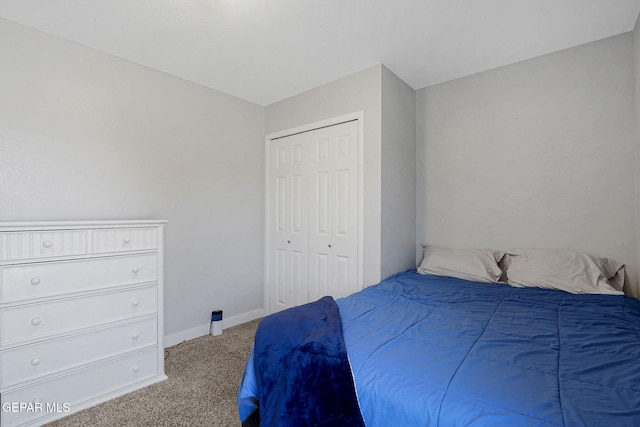 carpeted bedroom with a closet and baseboards