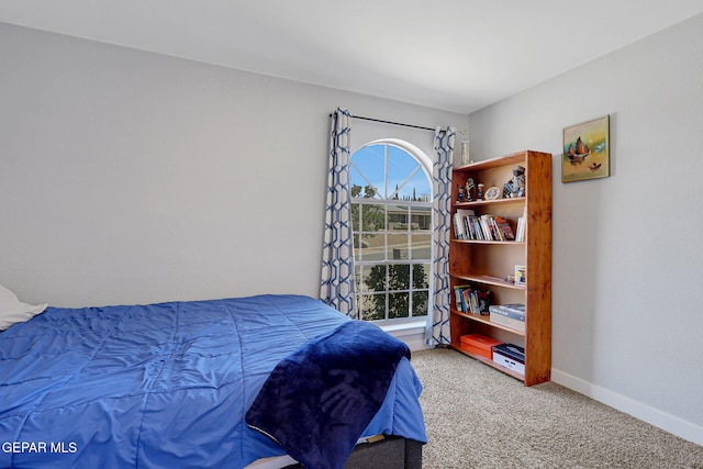 bedroom with light carpet and baseboards