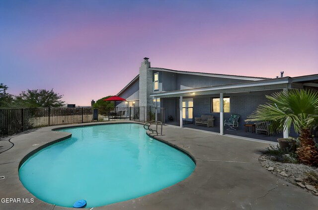 view of swimming pool featuring a patio, fence, and an outdoor hangout area
