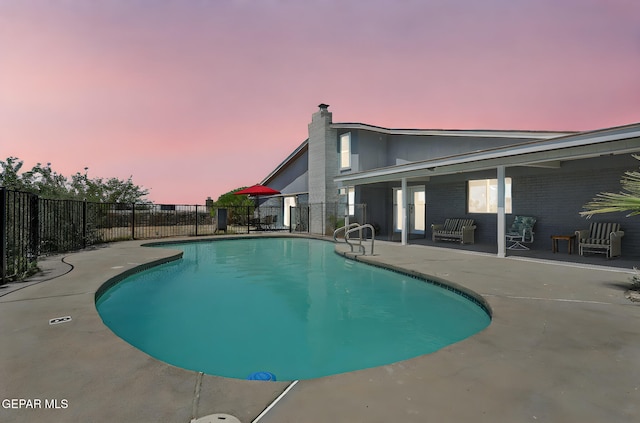 view of swimming pool with a patio and fence